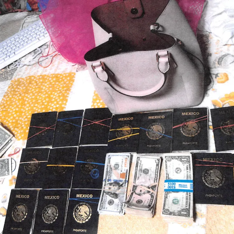 Quinze passeports mexicains et des piles de devises américaines sur une couverture patchwork devant un sac à main rose.